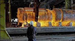 Worker watching forging process Worker watching forging process