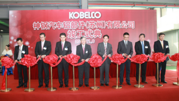 Executives of Kobe Steel Ltd and Kobe Aluminum Automotive Products China Co Ltd cut a ribbon to mark the completion of the project which is an estimated 89 million investment since it was initiated in 2010