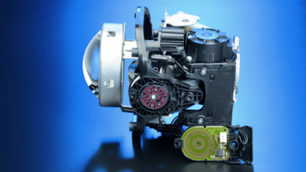 The light module for a dynamic bend lighting system includes sensors that measure the beam setting of the headlamps and adapts it depending on the load