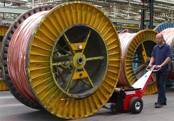 Man moving industrial sized spool with machine