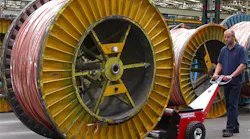 Man moving industrial sized spool with machine