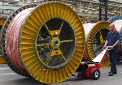 Man moving industrial sized spool with machine Man moving industrial sized spool with machine