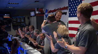 The Juno team celebrates at NASA&rsquo;s Jet Propulsion Laboratory in Pasadena, California, after receiving data indicating that NASA&rsquo;s Juno mission entered orbit around Jupiter. Rick Nybakken, Juno project manager at JPL, is seen at the center hugging JPL&apos;s acting director for solar system exploration, Richard Cook.