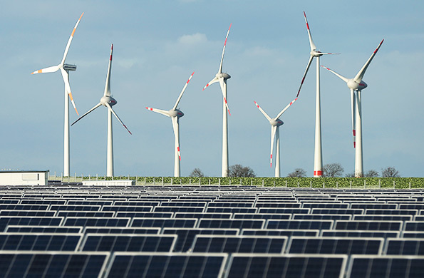 Solar panels and wind turbines in field