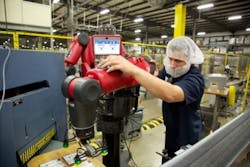 Worker using Baxter collaborative robot Worker using Baxter collaborative robot
