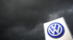 Volkswagen Logo on Sign Under Dark Clouds