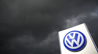 Volkswagen Logo on Sign Under Dark Clouds