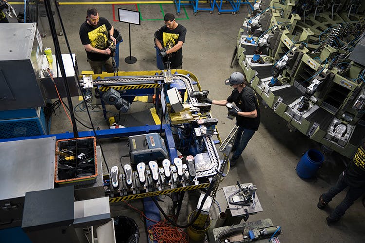 KEEN&apos;s Portland factory in action: humans to the left, injection molding to the right.