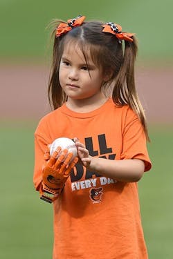 Hailey Dawson preparing to throw out the first pitch with her prosthetic hand at an Orioles game in 2015.
