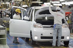 Toyota factory workers on assembly line Toyota factory workers on assembly line
