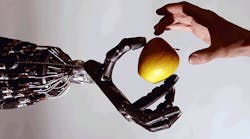Robotic hand passing apple to human