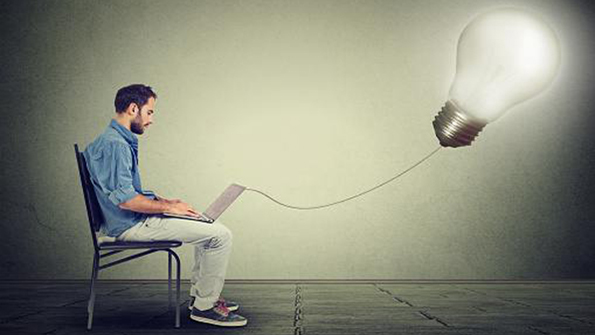 Man with laptop connected to lightbulb