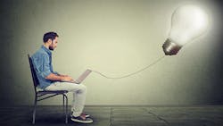 Man with laptop connected to lightbulb Man with laptop connected to lightbulb