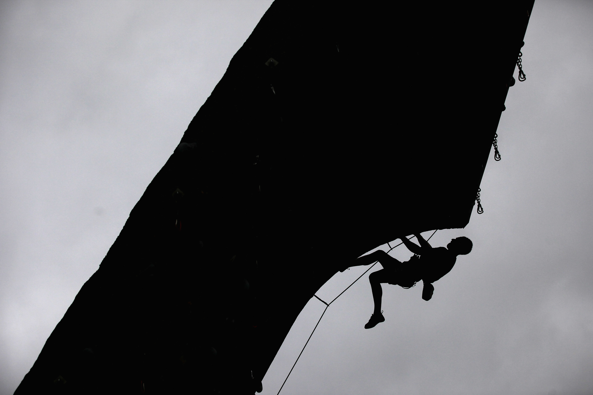 Man climbing wall with safety ropes