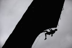 Man climbing wall with safety ropes Man climbing wall with safety ropes
