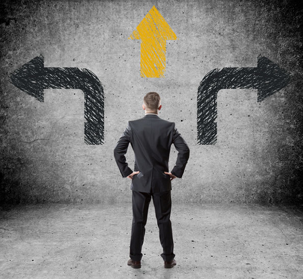 Man in suit standing in front of arrows pointing multiple directions