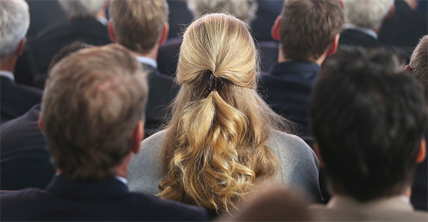 Woman sitting in crowd of men