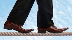 Dress shoes walking on tightrope