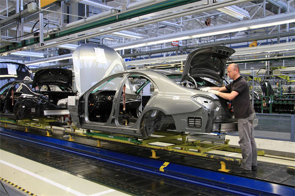 Worker assembling Mercedes Benz on assembly line