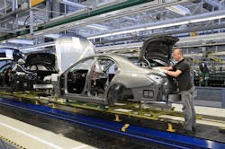 Worker assembling Mercedes Benz on assembly line Worker assembling Mercedes Benz on assembly line