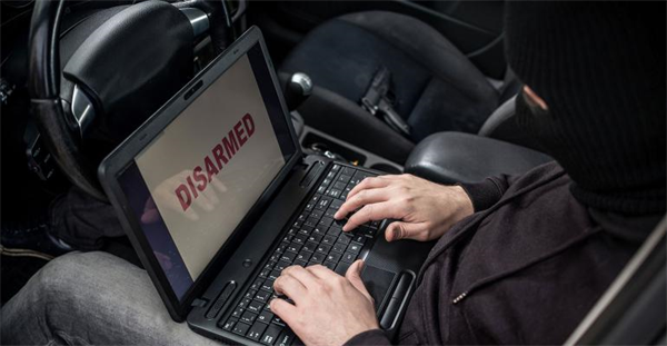 Man in ski cap using laptop in car