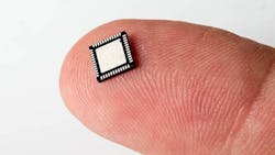 Micro chip resting on finger Micro chip resting on finger