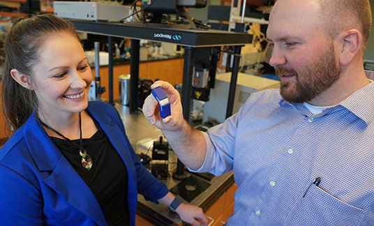 Travis Walker, Ph.D., holds an example of a 3D printed item made with two different materials. He and Katrina Donovan, Ph.D., say this object is a large-scale example of the kind of 3D printed materials now possible at scales smaller than a human hair.