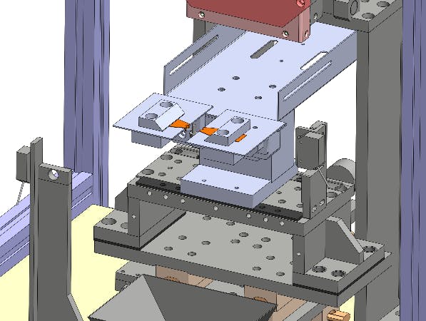 Fig.1: Shows the integration of the gripper in a welding cell. The orange parts are the copper inserts, the light grey shows the gripper and mounting plates, and the dark grey is the original setup.