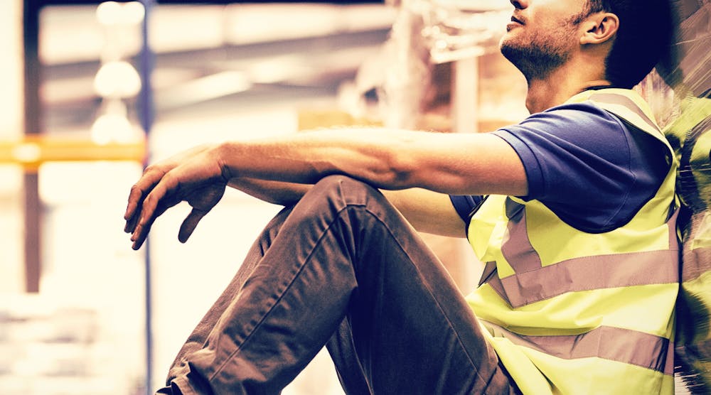 Tired manual worker sitting on the floor