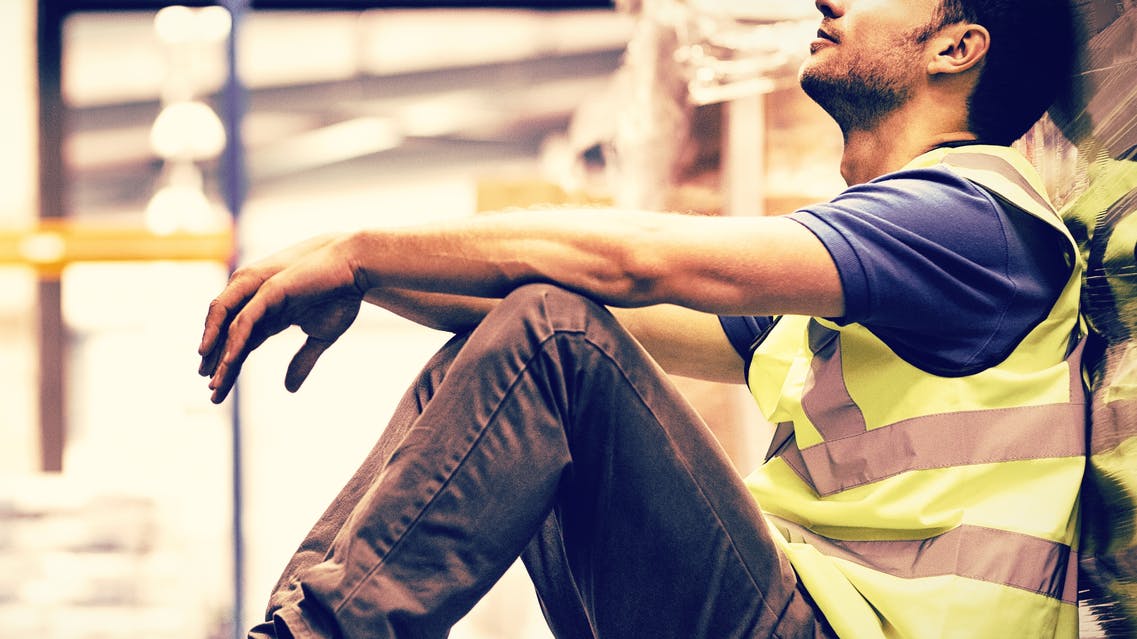Tired manual worker sitting on the floor.