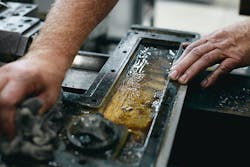 Worker wiping grease off part Worker wiping grease off part