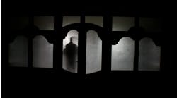 Silhouette of an unknown shadow figure on a door. Silhouette of an unknown shadow figure on a door.