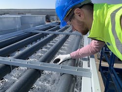 Worker Inspecting Evaporative Condensor Worker Inspecting Evaporative Condensor