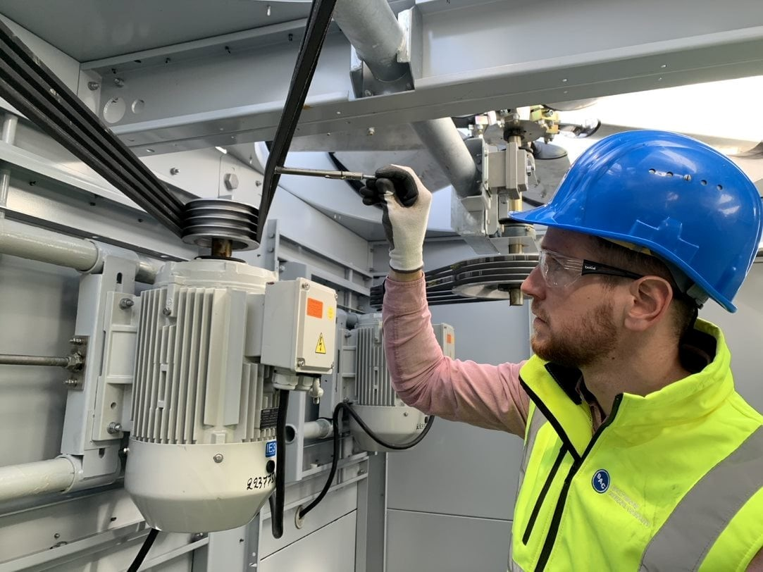 Worker inspecting condenser coil