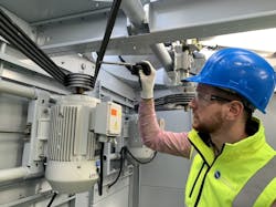 Worker inspecting condenser coil Worker inspecting condenser coil