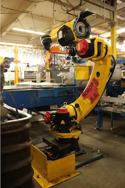 The Fanuc industrial robot at the heart of Behrens Metalware's automated cell for can cover production. The Fanuc industrial robot at the heart of Behrens Metalware's automated cell for can cover production.
