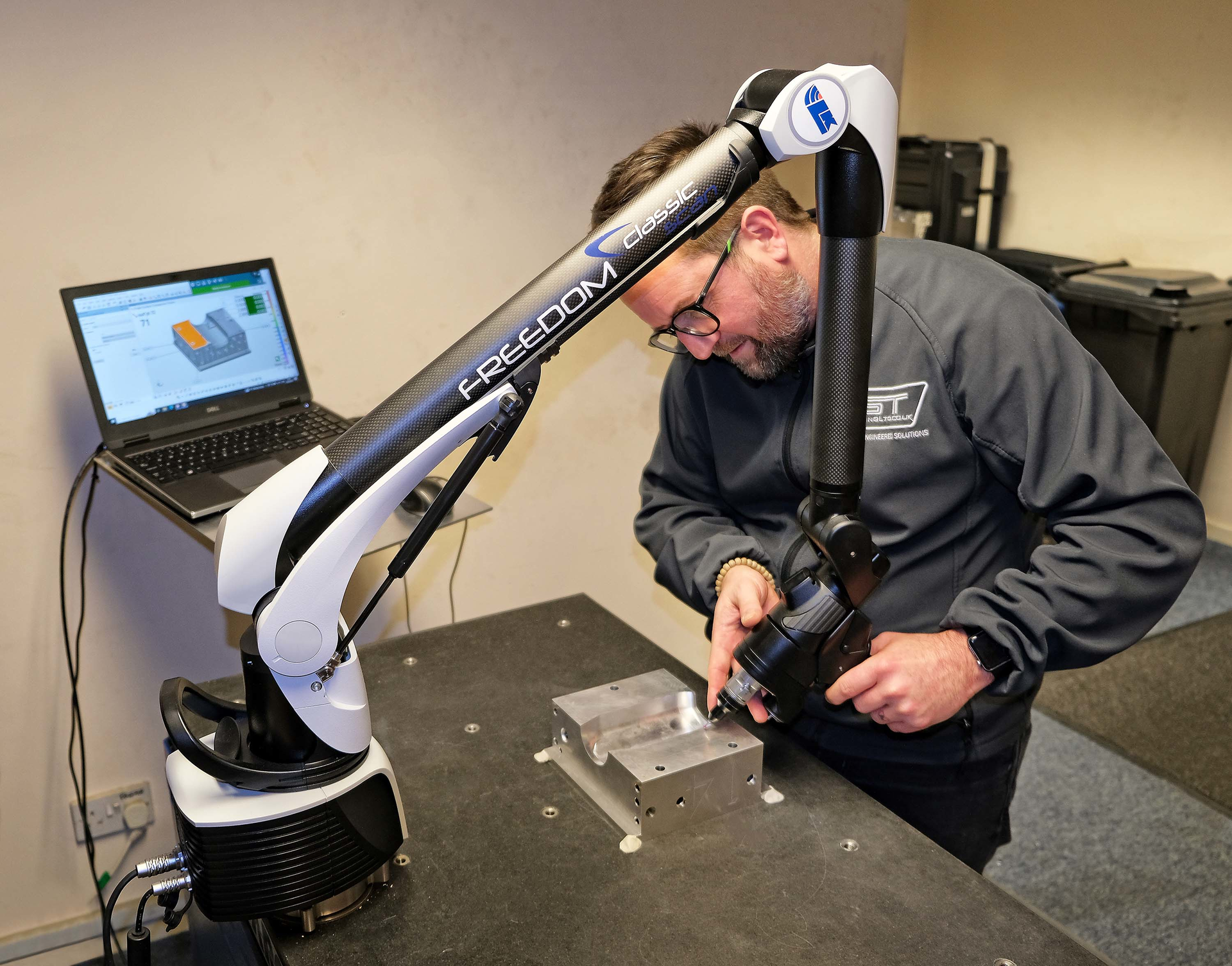 Ryan Leaves, who looks after inspection at GT Tooling, using the FREEDOM Classic Scan portable arm to inspect part of an aluminum extrusion blow mold for plastic bottle production.