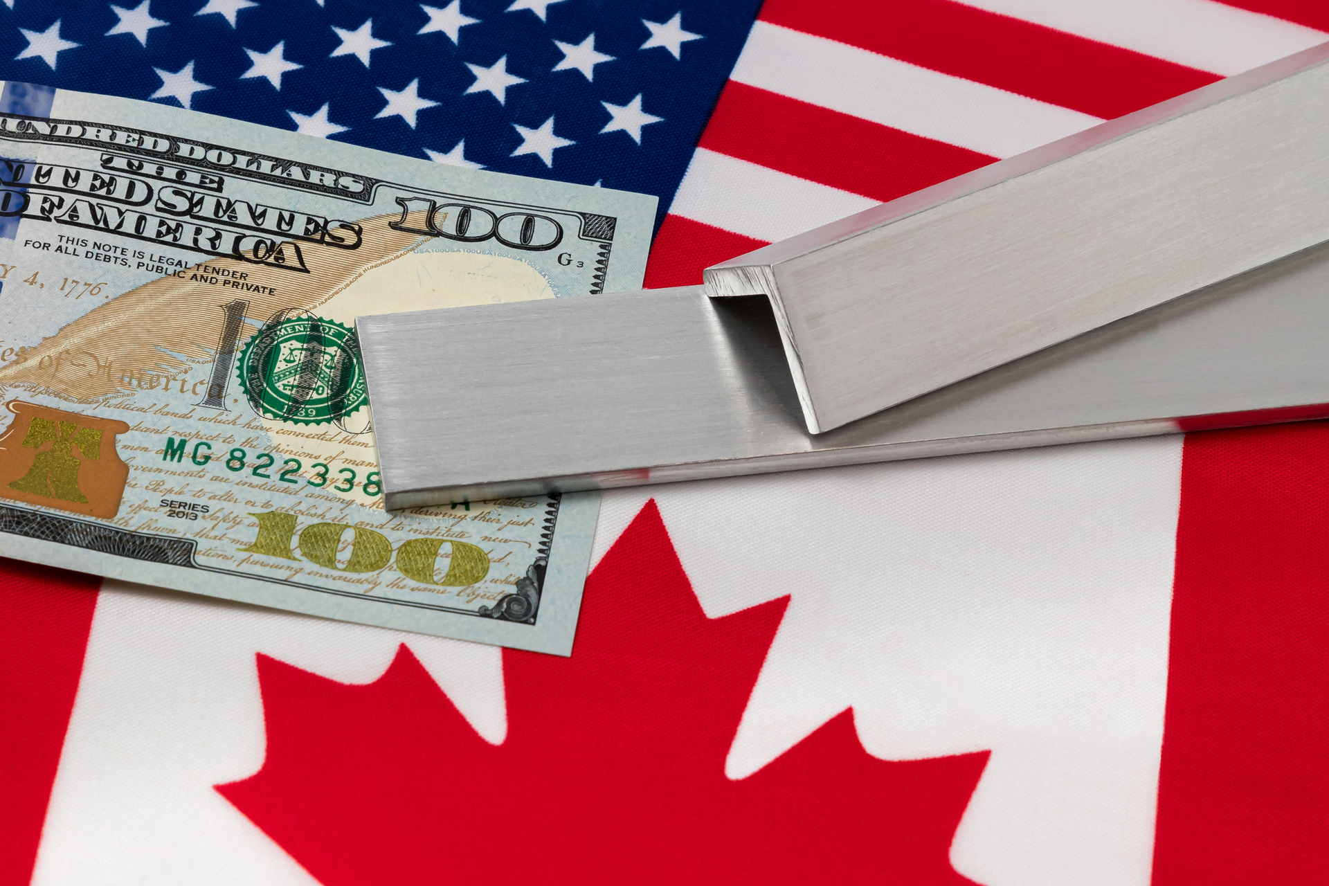 Aluminum and $100 bill on flags of USA and Canada