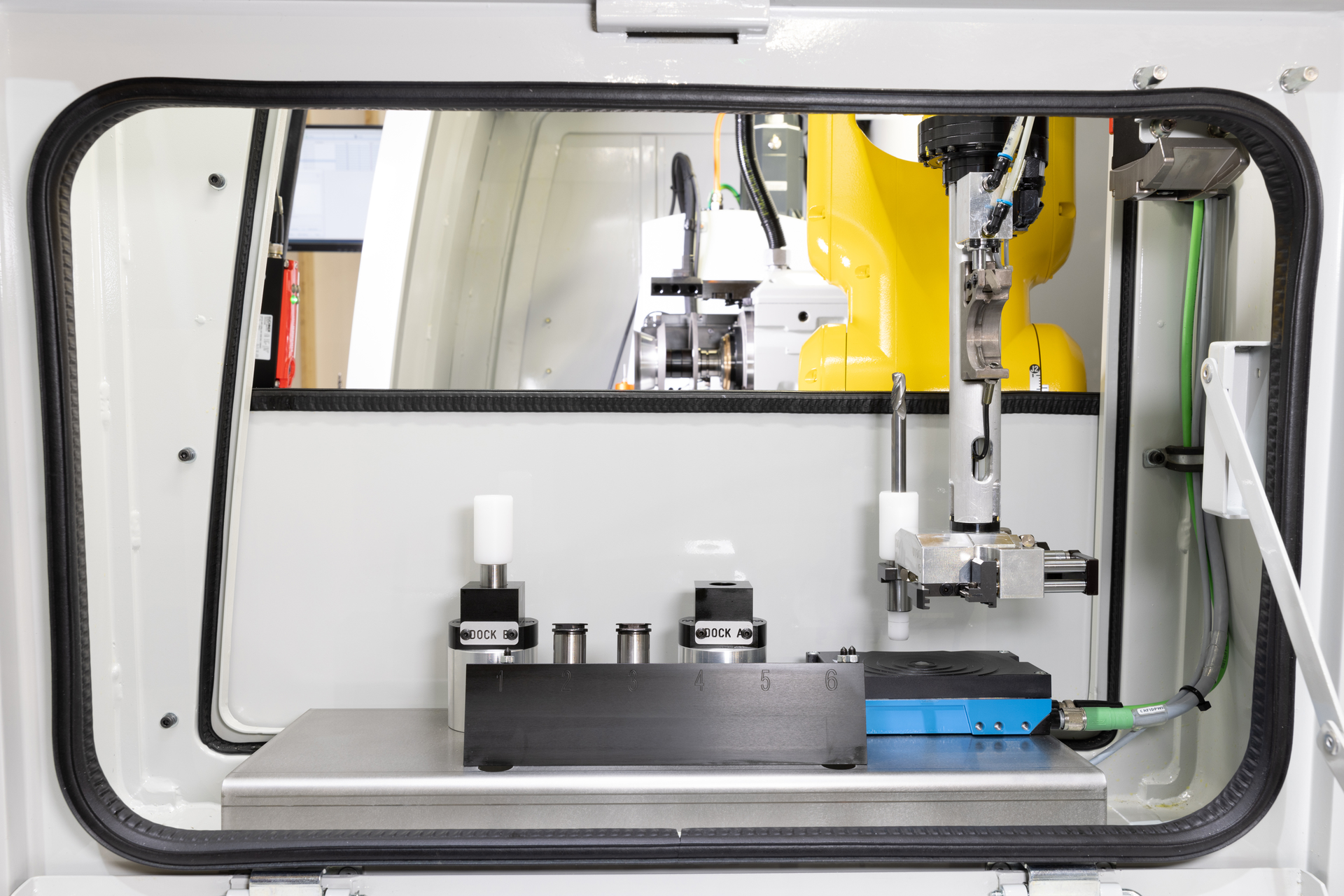 An inside view of ANCA's FX-RFID automated regrinding system using the robot to RFID scan on an ANCA machine.