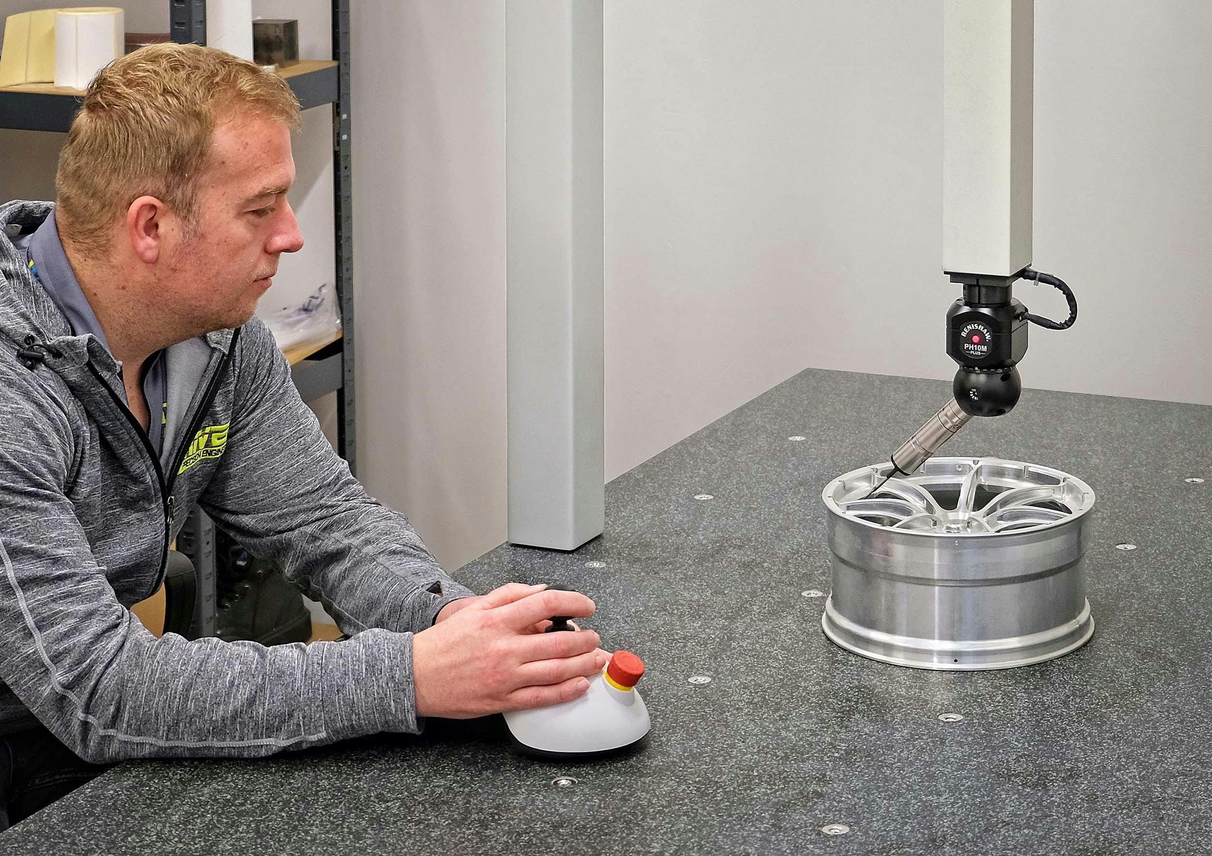 Ray Harris inspecting a scaled-down race car wheel for wind tunnel testing.