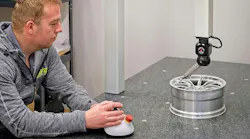 Ray Harris inspecting a scaled-down race car wheel for wind tunnel testing.
