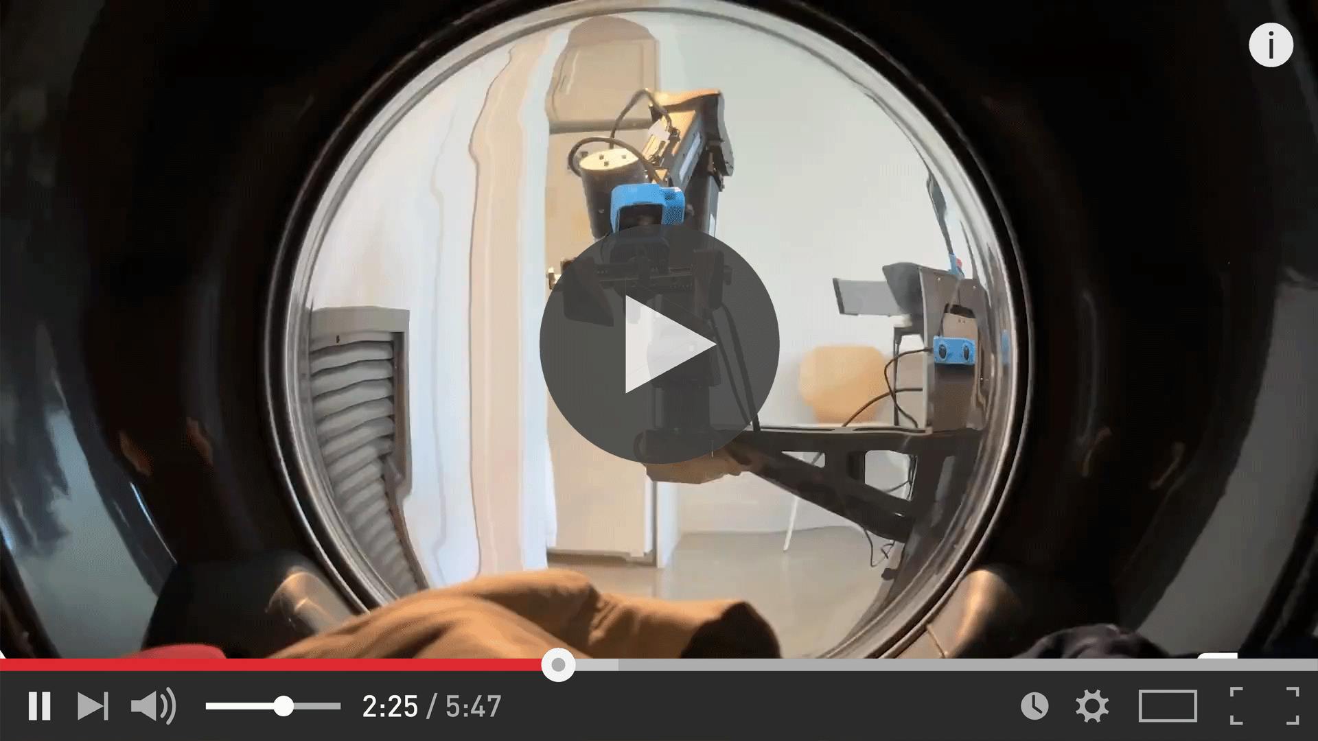 Inside a clothes dryer looking out the dryer window at Physical Intelligence's &pi;0 (pi-zero) maid robot