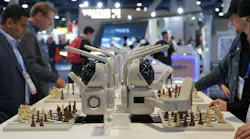SenseRobot's Chess robot on display with CES attendess interacting and playing chess with them at a table.