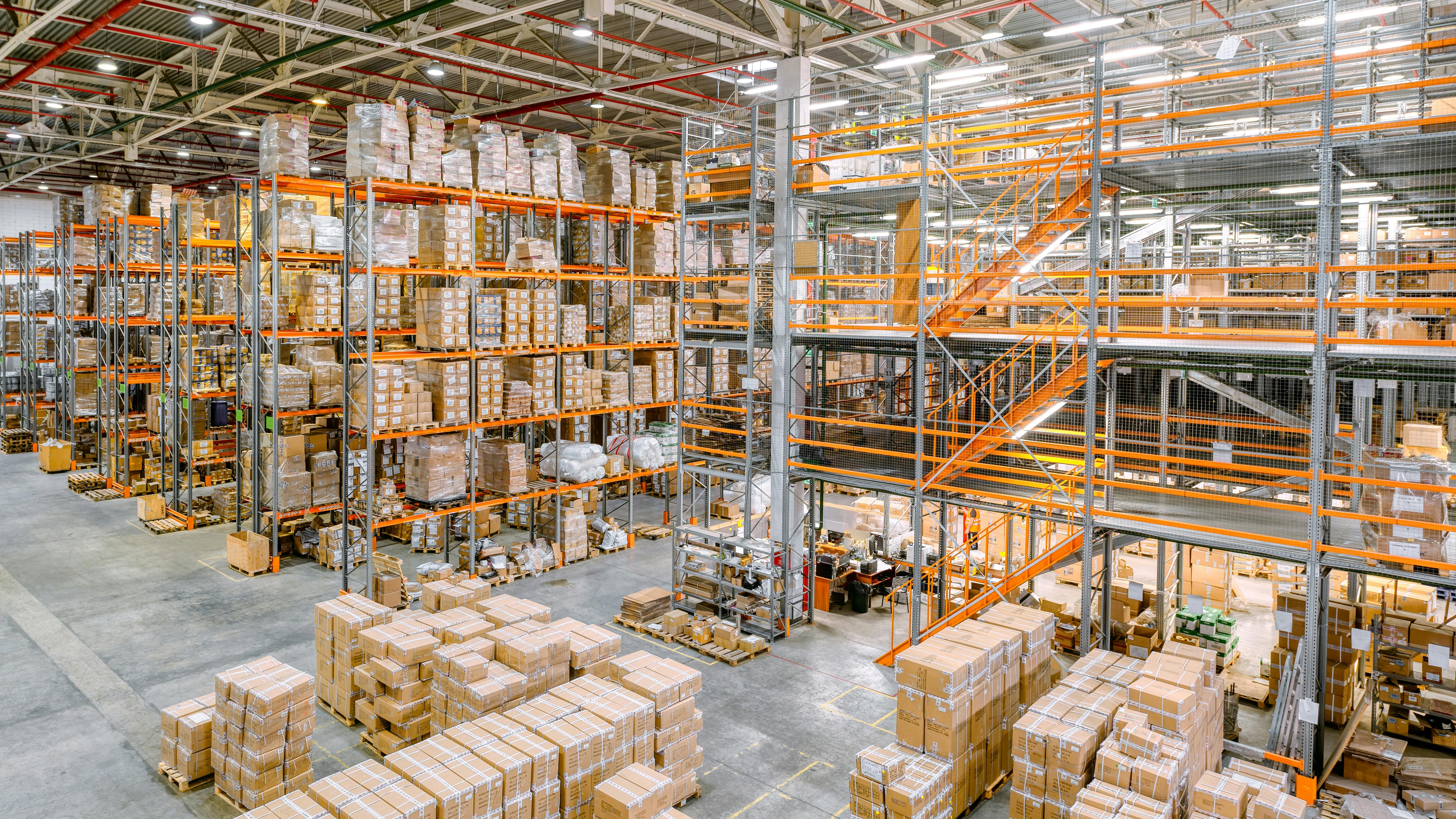 Large industrial warehouse with racks completely filled with boxes and containers.