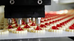 Jam cookies being produced in a factory on an assembly line. Jam cookies being produced in a factory on an assembly line.
