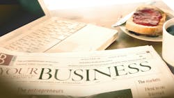 Newspaper business section sitting at desk with laptop and breakfast. Newspaper business section sitting at desk with laptop and breakfast.