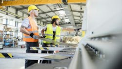 Male manual workers manufacturing sheet metal at industry. Male manual workers manufacturing sheet metal at industry.