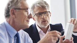 Two mature businessman discussing business plans in the modern office Two mature businessman discussing business plans in the modern office