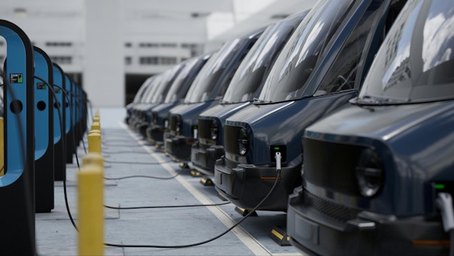 CU shot of fleet modern electric EV delivery vans are being charged in company parking garage