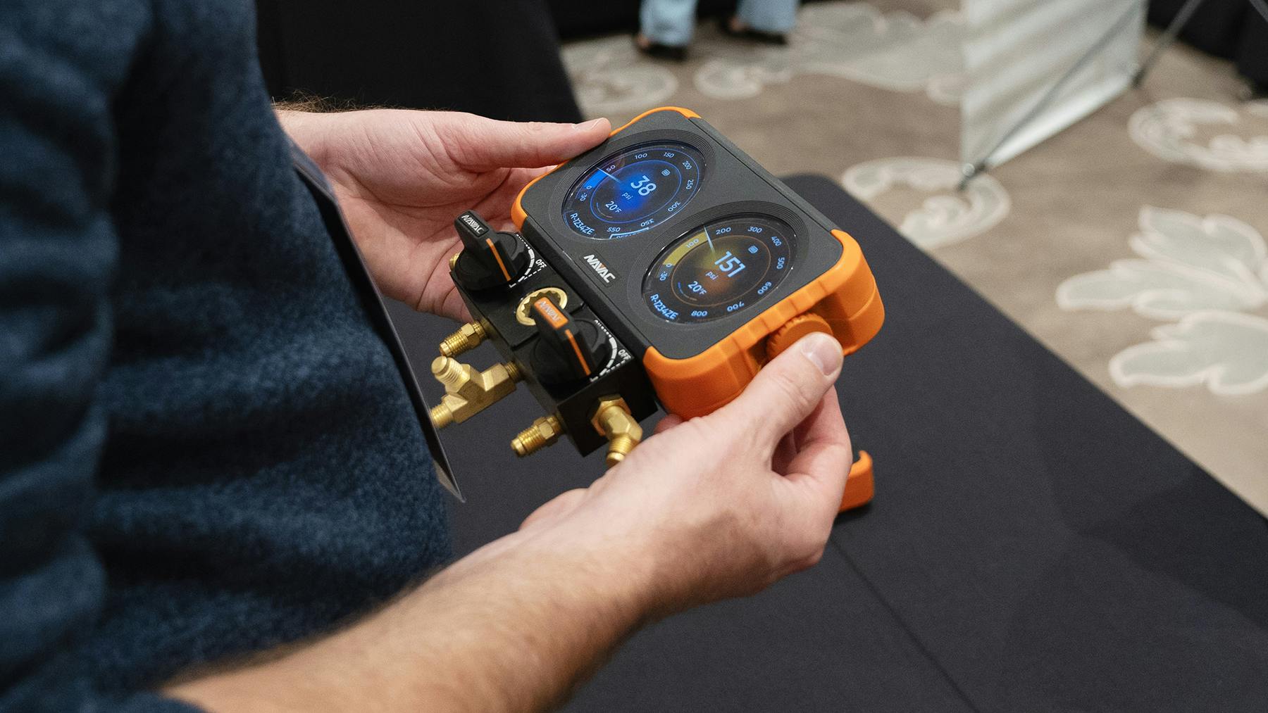 NAVAC Flex-X Manifold Gauge being held in users hands at tradeshow